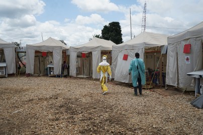 Doctors in hazmat suits walking through medical field operations tents