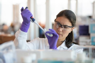Woman scientist injecting solution into test tube