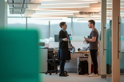 Two colleagues talking by desk