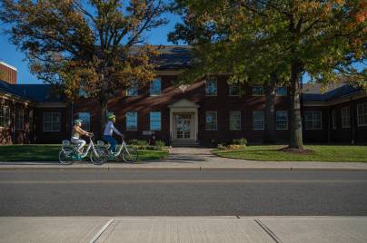 Couple riding bikes past house