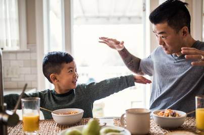 boy and his dad playing at breakfast
