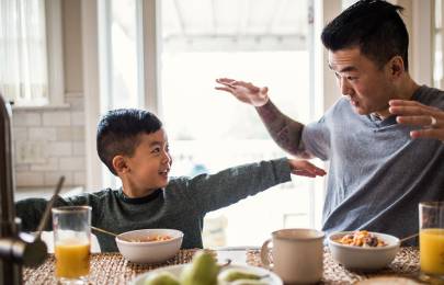 boy and his dad playing at breakfast
