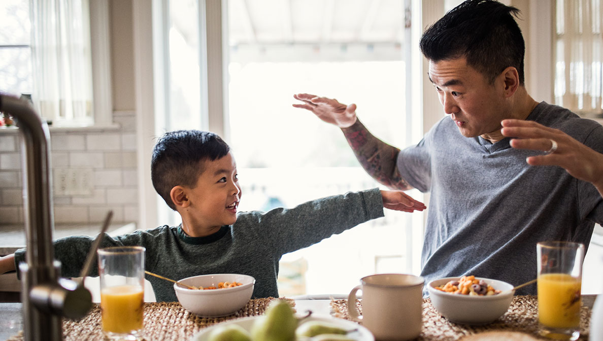boy and his dad playing at breakfast