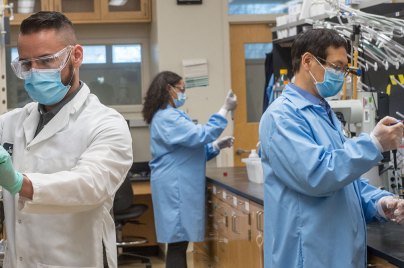 scientists wearing masks working in a lab