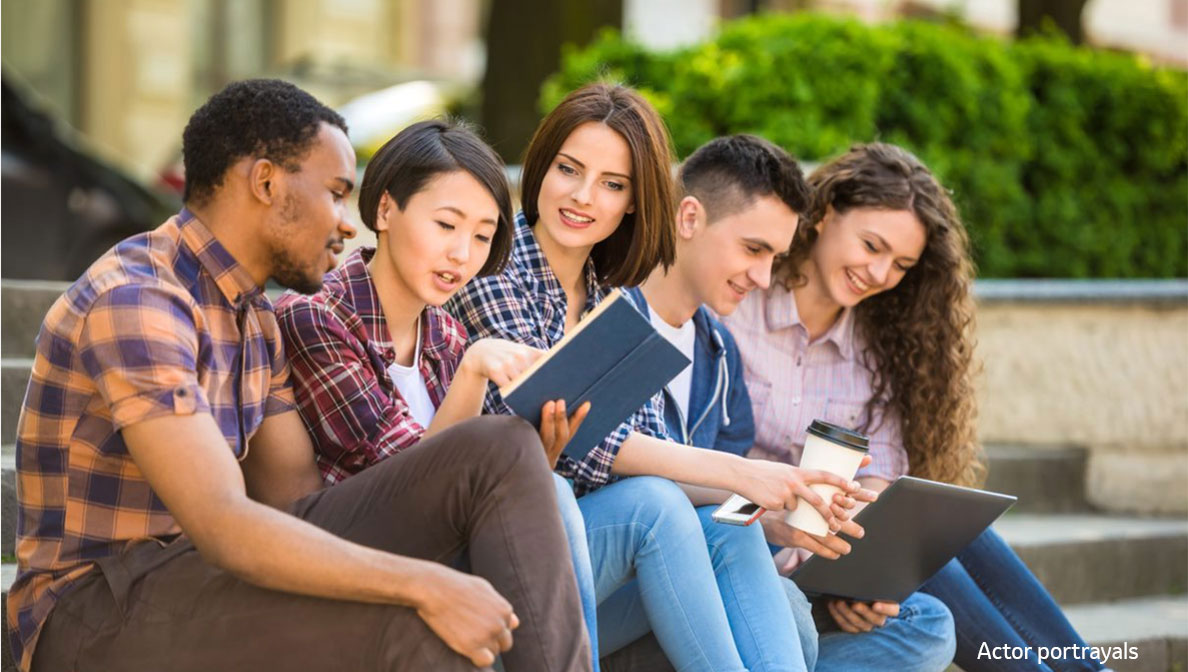 young adults sitting on the steps of a building