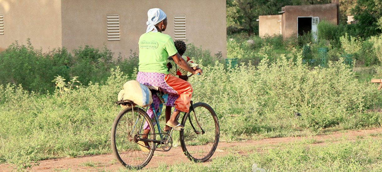 Mother and child on bicycle in Konkourona, Burkina Faso
