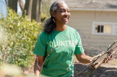 volunteer picking up tree branches