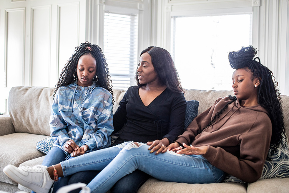 Three women sit on couch