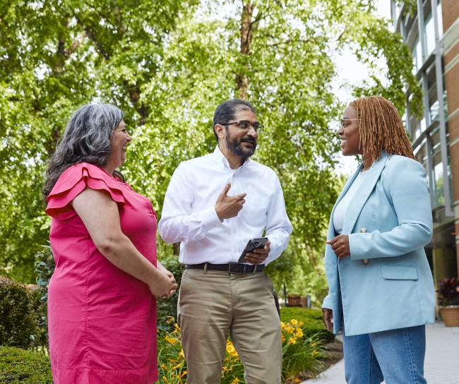 two women and a man talking