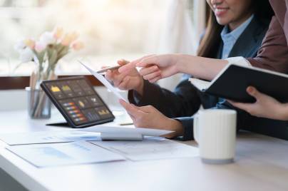 hands of women in suits using data dashboard