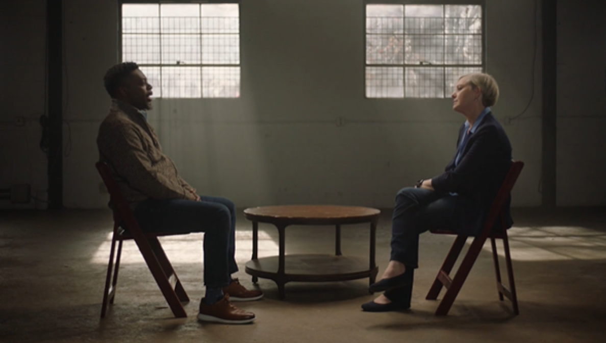 two people having conversation sitting across each other in dark room