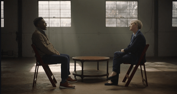 two people having conversation sitting across each other in dark room