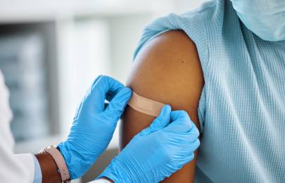 healthcare working putting a bandaid on a child's arm