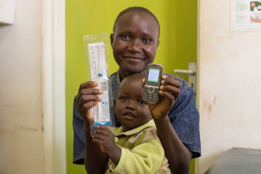 a woman holding a baby and a cell phone