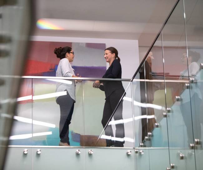two women talking in an office building