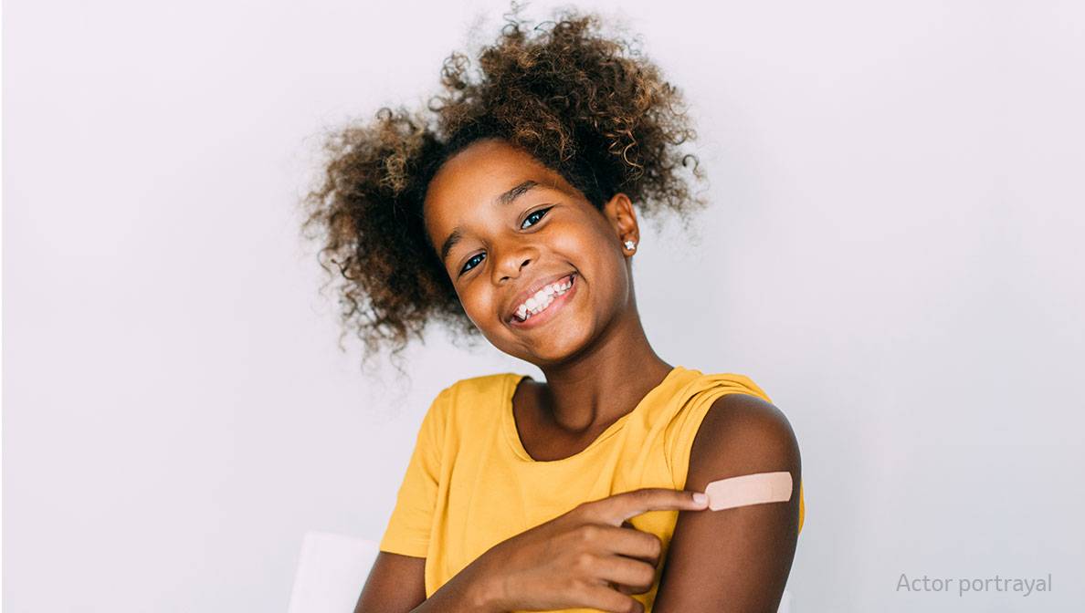 smiling child with band aid on her arm
