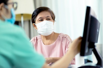 doctor speaking to patient in mask