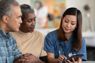two senior adults reviewing health care information with a provider