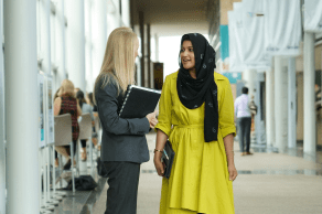 Two employees talking in a hallway