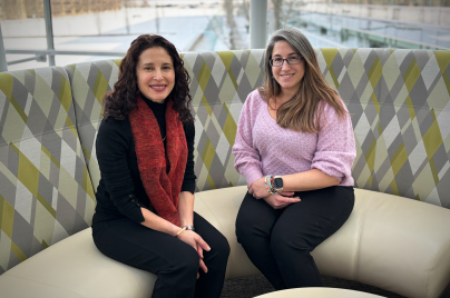 two women sitting down in round sofa