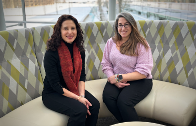 two women sitting down in round sofa