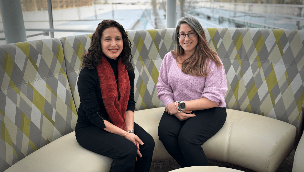 two women sitting down in round sofa