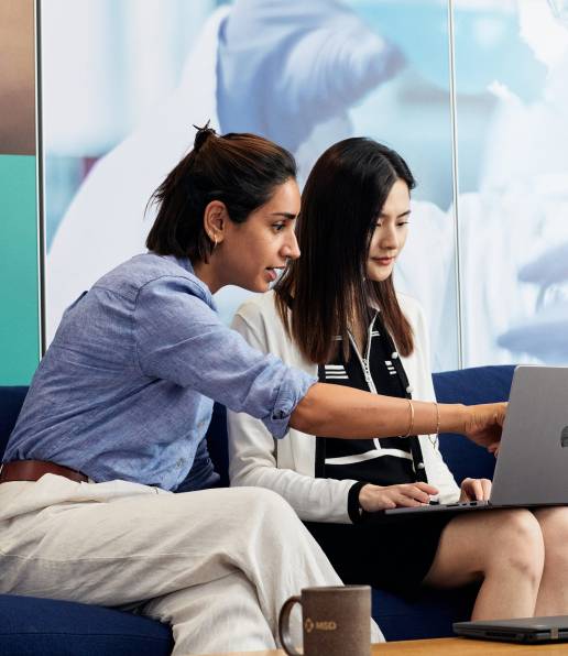 two colleague having conversation pointing at laptop screen