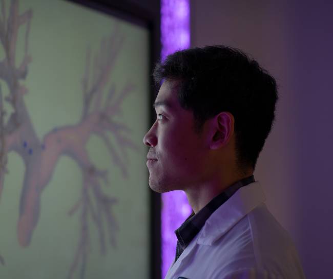 person on white coat looking at the screen