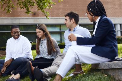 employees sitting on the grass talking