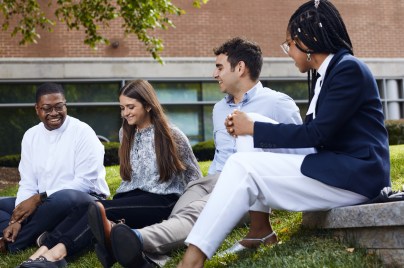 employees sitting on the grass talking