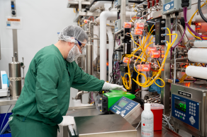 Person in green protective gear operating in the lab