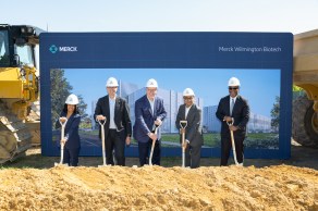 Group of people holding shovels wearing hardhat with merck logo