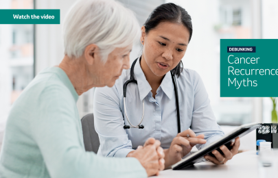 photo of a doctor holding clipboard and pointing something out to the woman sitting next to her