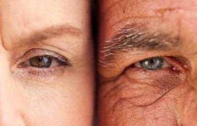 Close-up of two eyes side by side, showing contrast in skin tone and eye color between two individuals.