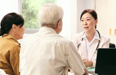 couple being consulted by a female doctor wearing a white coat