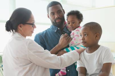 family being consulted by doctor wearing white coat