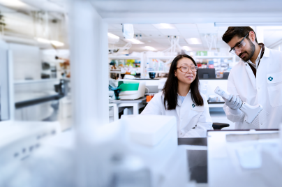 two scientists wearing lab coats working in a lab