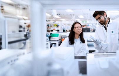 two scientists wearing lab coats working in a lab