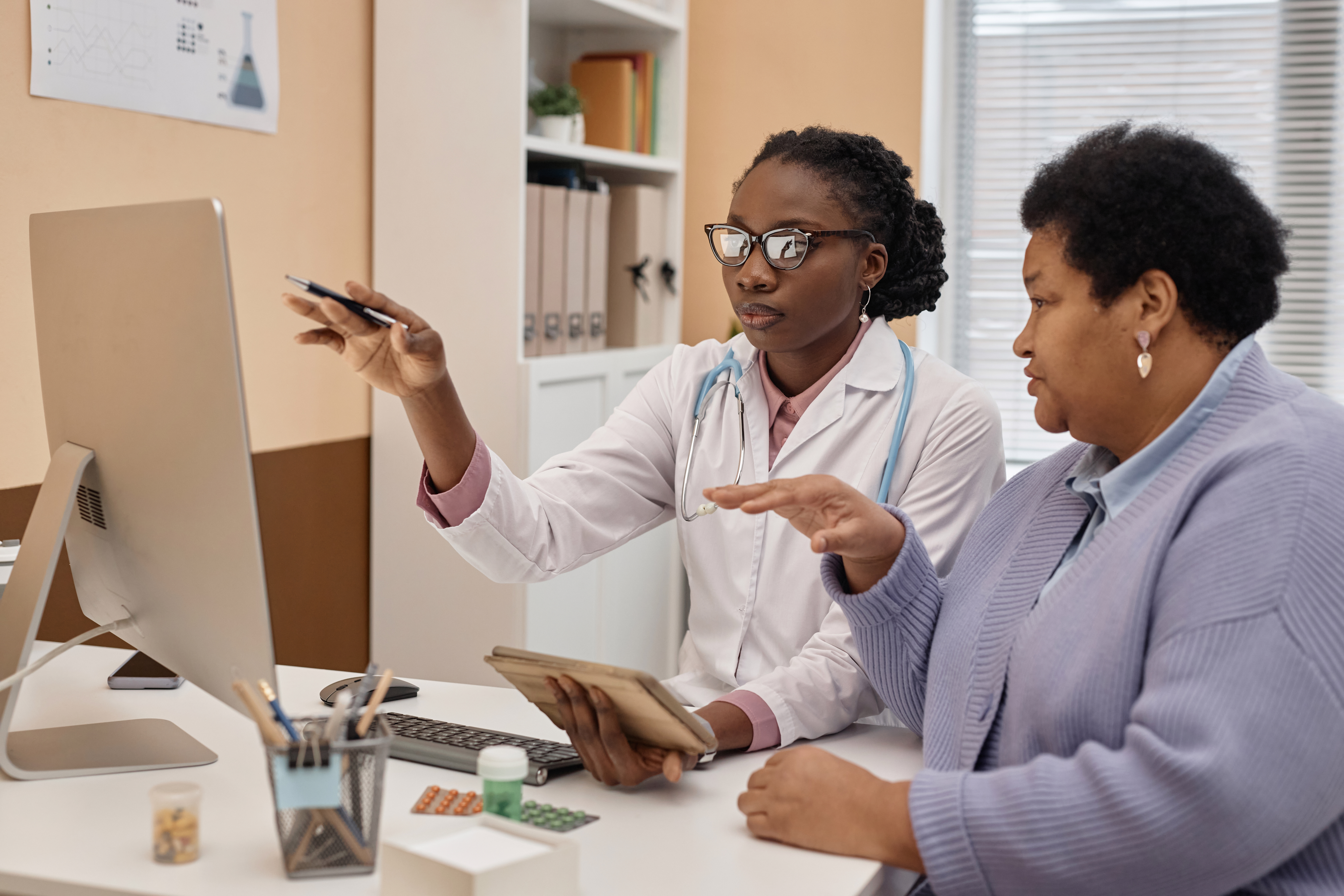 Health practitioner explaining medical test to female patient in hospital room