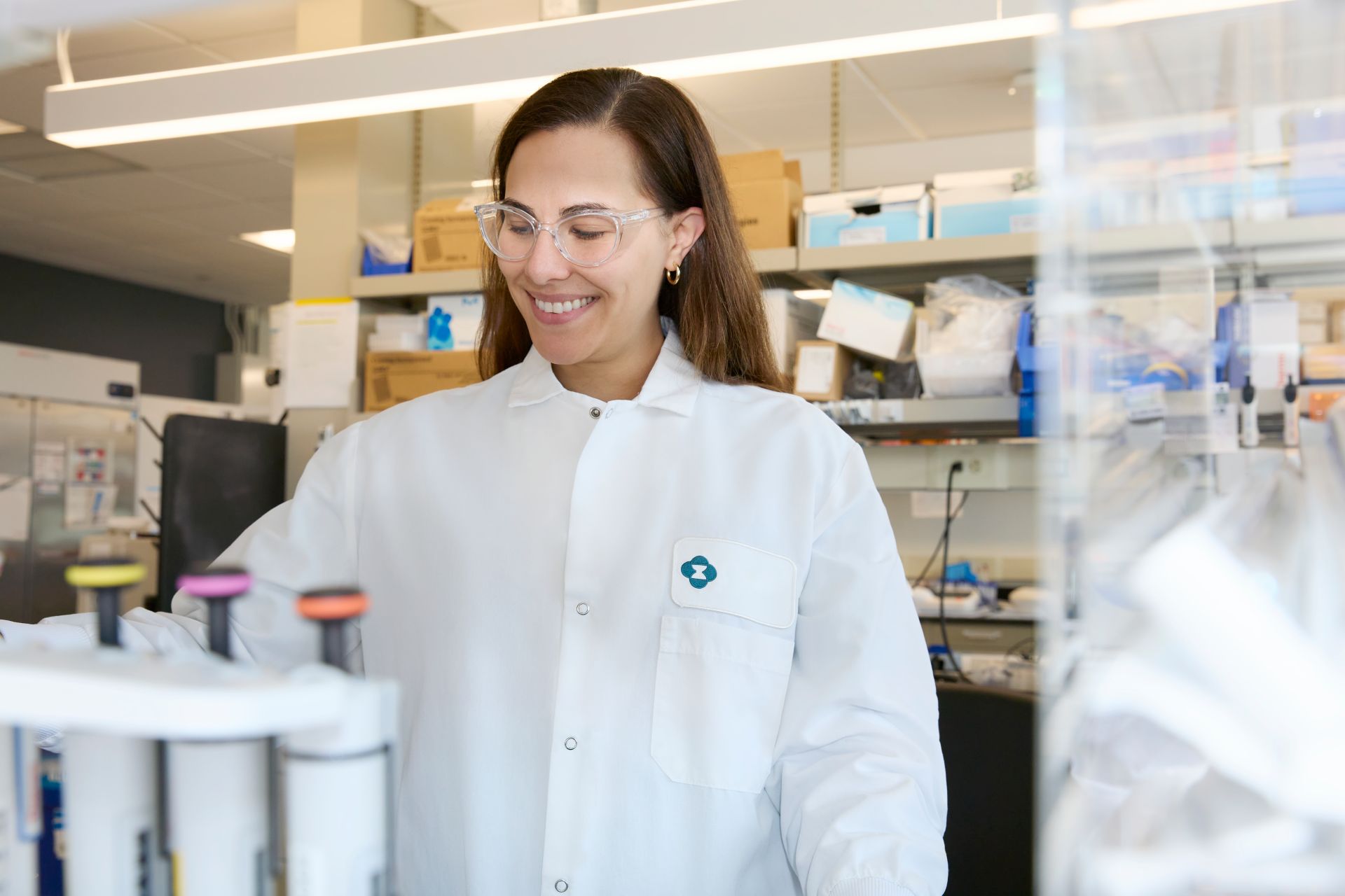 scientist wearing white lab coat and protective goggles working in a lab