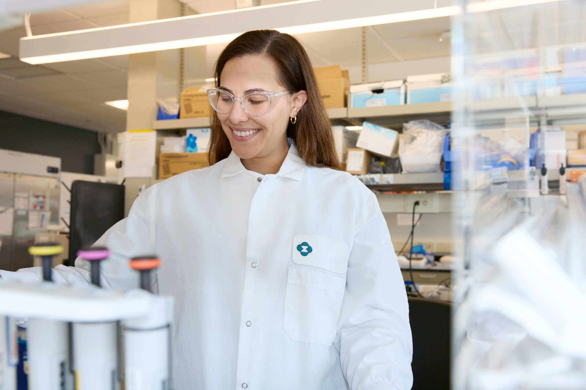 scientist wearing white lab coat and protective goggles working in a lab