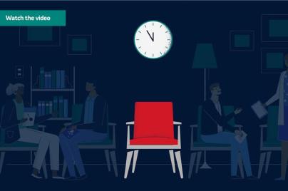 Red chair with clock above it and shadows of patients in the background