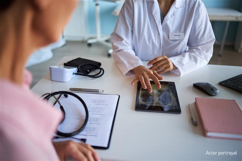 two people with lab coats looking at an medical scan.