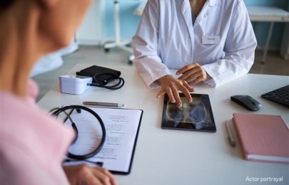 two people with lab coats looking at an medical scan.