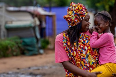 photo of mother holding a a baby and they're smiling at each other