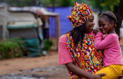 photo of mother holding a a baby and they're smiling at each other