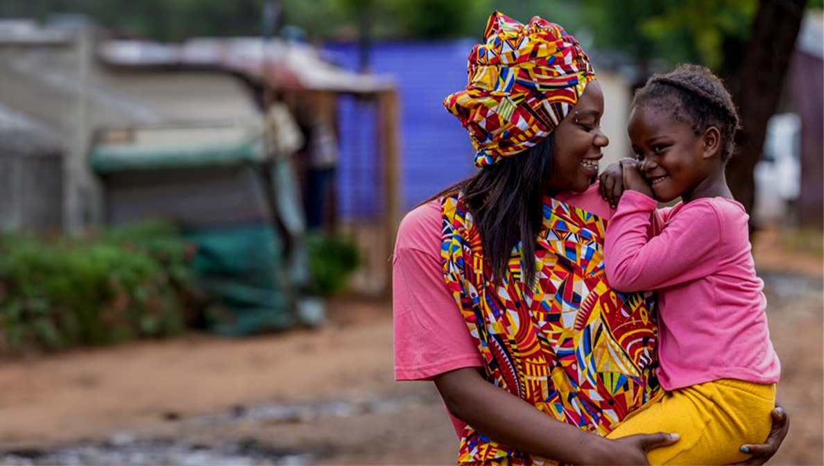photo of mother holding a a baby and they're smiling at each other