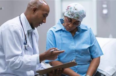 doctor talking with patient and looking at clipboard