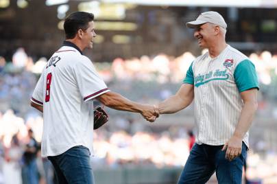 two men wearing baseball jerseys shaking hands