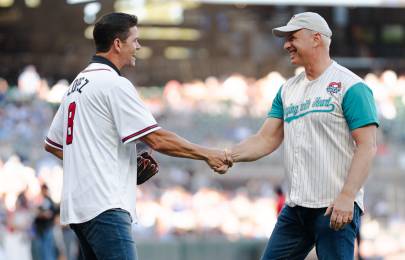 two men wearing baseball jerseys shaking hands